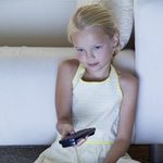 Young girl holding TV remote
